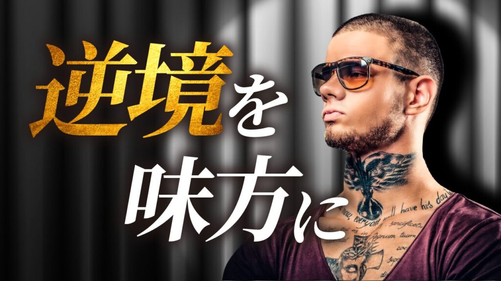 舞台の幕の前で、サングラスをかけタトゥーを入れた男性が毅然とした表情でポーズをとる写真に、『逆境を味方に』という文字を重ねた自己啓発系YouTubeサムネイルの作例。（バイブデザインのおもち制作）